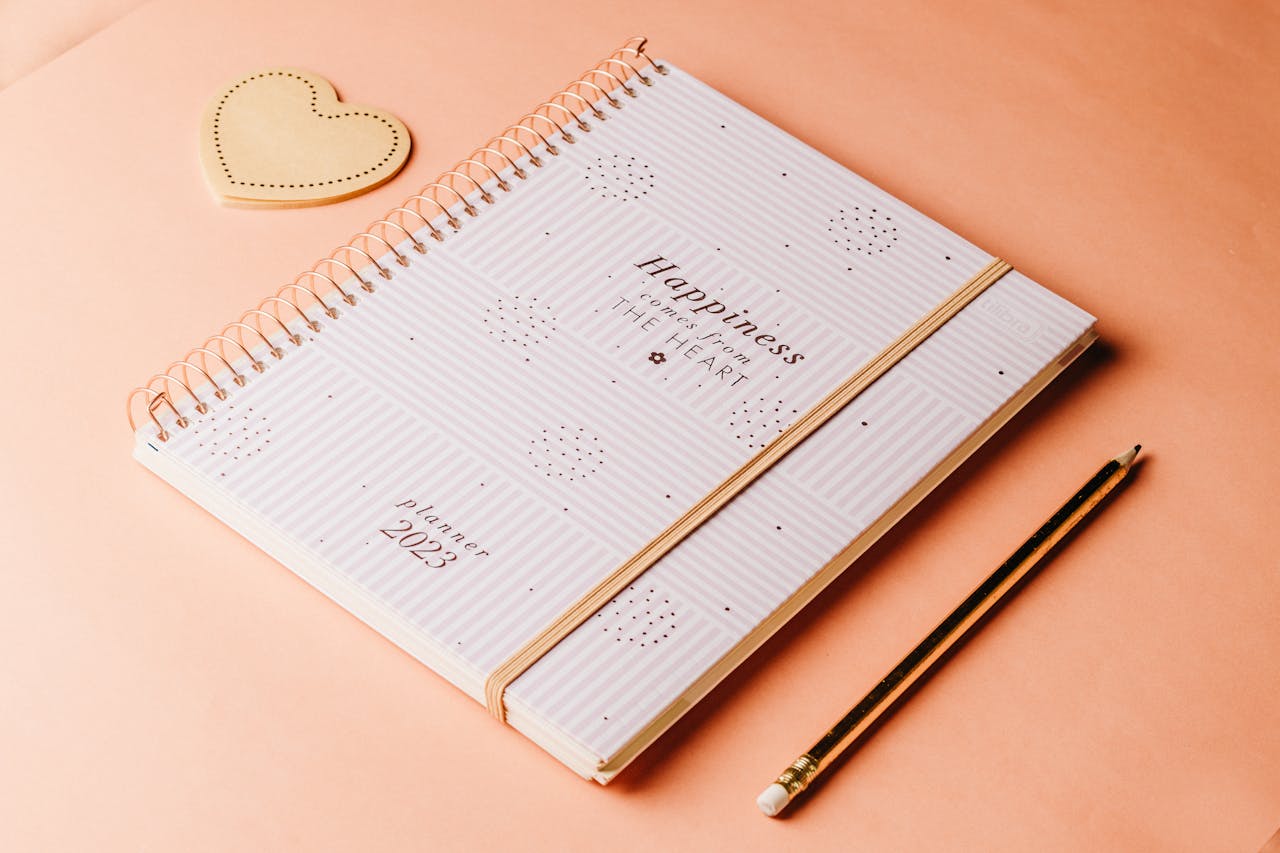 Black Framed Eyeglasses Near a Flower and a Clipboard on Paper